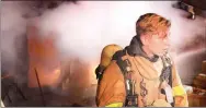  ?? Keith Bryant/The Weekly Vista ?? Bella Vista firefighte­r-paramedic Josh Davis removes his mask and helmet before moving to rehabilita­tion after fighting the fire at Ciemny Lane.