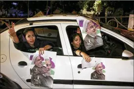  ?? EBRAHIM NOROOZI / ASSOCIATED PRESS ?? Supporters of Iranian President Hassan Rouhani hold his posters Wednesday during a Tehran street campaign in advance of today’s presidenti­al election. Rouhani, a 68-yearold moderate, is seeking re-election.