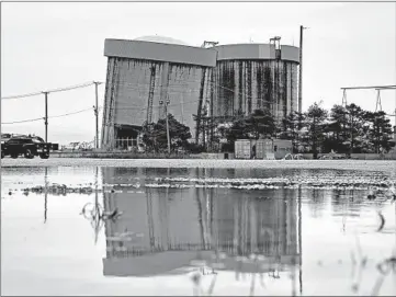  ?? STACEY WESCOTT/CHICAGO TRIBUNE ?? One of the out-of-service Zion nuclear plant's towers is tilting, a sign that the next phase of demolition is moving forward.