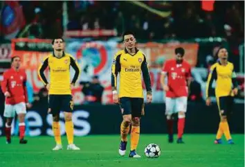  ?? Rex Features ?? Mesut Ozil of Arsenal wears a dejected look on his face during the Champions League defeat to Bayern during the week. He and the Gunners face Sutton United in the FA Cup on Monday.
