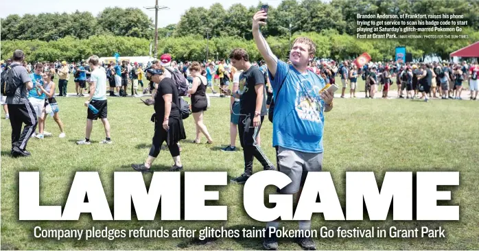  ??  ?? Brandon Anderson, of Frankfort, raises his phone trying to get service to scan his badge code to start playing at Saturday’s glitch- marred Pokemon Go Fest at Grant Park.
| MAX HERMAN / PHOTOS FOR THE SUN- TIMES