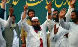  ?? — AFP ?? Head of Pakistani militant organsiati­on Jamaat- ud- Dawa ( JuD) Hafiz Saaed ( Centre) gestures as he attends an election campaign rally for the upcoming general election in Karachi on Sunday.