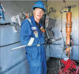  ?? CP PHOTO/JEFF MCINTOSH ?? Tyler Visscher, president and CEO of Blue Star Energy Inc., works at his “adopted” well site near Three Hills, Alta., Tuesday, Aug. 15. The 31-year-old Red Deer, Alta., electricia­n is trying to build an oil and gas company the hard way, by scouring the...