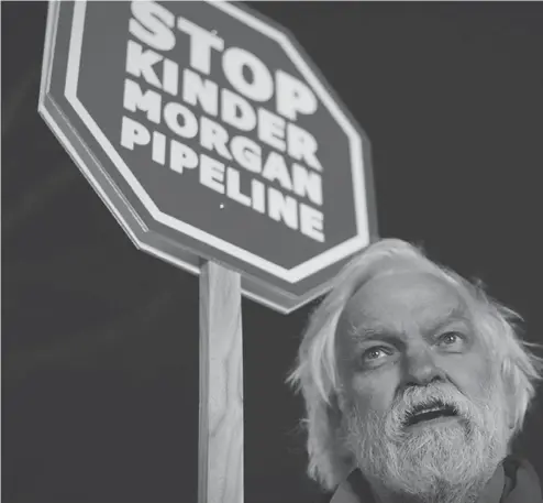  ?? DARRYL DYCK / THE CANADIAN PRESS ?? Protester Paul George holds a sign during a Vancouver demonstrat­ion against the Kinder Morgan Trans Mountain pipeline expansion project.