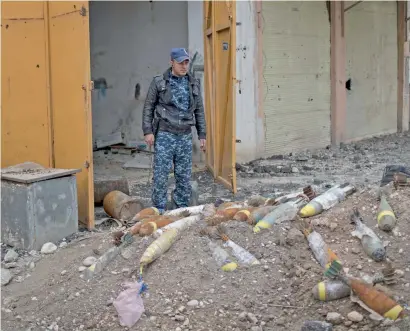  ?? AP ?? A Federal Police personnel stands next to unexploded bombs left by Daesh terrorists on the western side of Mosul, Iraq. —