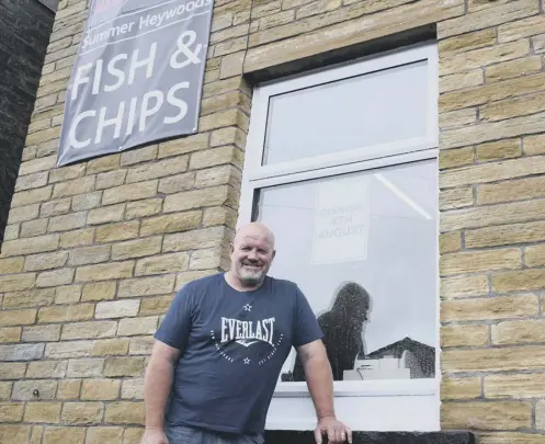  ??  ?? FRIENDLY GIANT: Standing at 6ft 4in, Mr Fogerty stands outside his chip shop, on Gibbet Street, Halifax