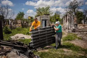  ?? Dimitar Dilkoff, Afp/getty Images ?? A woman and her son remove the remains of their burned home Wednesday in the village of Andriivka amid the Russian invasion of Ukraine.