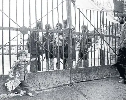  ?? THE ASSOCIATED PRESS FILE PHOTOS ?? An Iranian child holds a photo of Ayatollah Khomeini in front of the U.S. Embassy in Tehran on Nov. 6, 1979, the third day of the building’s occupation by Iranian students. They were holding scores of American hostages inside the compound.