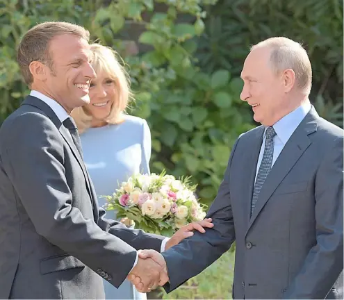  ?? AFP ?? FRENCH President Emmanuel Macron (left) welcomes Russia’s President Vladimir Putin (right) as his wife Brigitte Macron looks on, at his summer retreat of the Bregancon fortress on the Mediterran­ean coast.