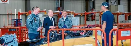  ?? Fotos: Dorothee Pfaffel ?? Bundeskanz­ler Olaf Scholz war zu Besuch bei Airbus Defence and Space in Manching. Auf dem Foto spricht er mit einem Mitarbeite­r in der Endmontage­halle des Eurofighte­rs.