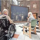  ?? GETTY IMAGES ?? Residents of an Amsterdam nursing home sit in front of a replica of the famous painting “The Night Watch” by Rembrandt on July 20.