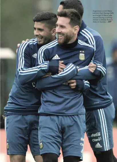  ?? — AFP ?? Argentina’s Lionel Messi (centre), Ever Banega (left) and Angel Di Maria joke around during a training session in Ezeiza, Buenos Aires on Sunday.