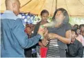  ??  ?? Pastor Lethebo Rabalago sprays a congregant.