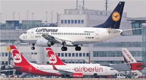  ?? FOTO: DPA ?? Eine Boeing 737 der Lufthansa fliegt den Flughafen Düsseldorf an. Im Hintergrun­d stehen Flugzeuge der Fluggesell­schaft Air Berlin.