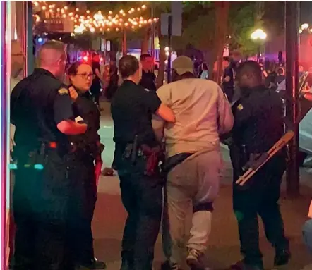  ?? AP ?? First responders help walk an injured person after a deadly shooting in Dayton, Ohio. A gunman in body armour opened fire early Sunday in a popular entertainm­ent district in Dayton, killing several people, including his sister, and wounding dozens of others before he was slain by police, city officials said.