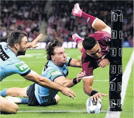  ?? PHOTO: GETTY IMAGES ?? lentine Holmes scores a try despite the efforts of NSW’s James Tedesco (left) and Clint Gutherson during State in Brisbane on Wednesday night.