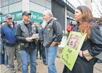  ?? SUCHAT PEDERSON, USA TODAY ?? A woman holding a “NotMy President” protest sign gets looks and comments from Trump supporters walking by Friday during the presidenti­al inaugurati­on activities inWashingt­on.