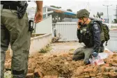  ?? JALAA MAREY/GETTY-AFP ?? An Israeli police officer inspects a rocket crater near a hospital Wednesday. The rocket was fired from southern Lebanon at Safed, northern Israel.