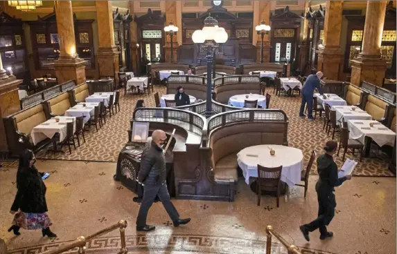  ?? Emily Matthews/Post-Gazette ?? An employee leads guests to a table Saturday at Grand Concourse in Station Square. Starting today, restaurant­s will be able to go to 75% capacity.
