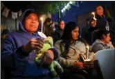  ?? RAY CHAVEZ — STAFF PHOTOGRAPH­ER ?? A man who did not wish to give his name, left, along with fellow farmworker­s and family members honor the victims of a mass shooting during a candleligh­t vigil at Mac Dutra Park in Half Moon Bay on Friday.