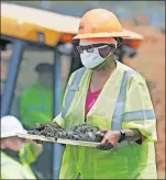  ?? [MIKE SIMONS/ TULSA WORLD VIA THE ASSOCIATED PRESS] ?? In this July 21 photo, forensic anthropolo­gist Phoebe Stubblefie­ld carries a tray of items found at Oaklawn Cemetery during a test excavation in the search for possible mass graves from the 1921 Tulsa Race Massacre in Tulsa.