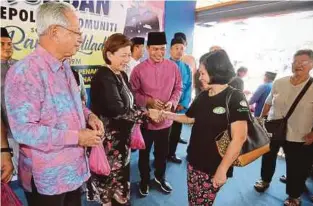  ?? [Foto Khairull Azry Bidin /BH] ?? Ahli Dewan Undangan Negeri (ADUN) Kepayan, Jannie Lasimbang bersama Uda (kiri) menyerahka­n daging korban kepada orang ramai sambil diperhati Haris (tiga dari kiri) di Penampang , kelmarin.