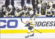  ?? Elsa / Getty Images ?? Former Quinnipiac defenseman Connor Clifton is congratula­ted by his Boston Bruins teammates after tying Monday’s playoff game against the Carolina Hurricanes. Clifton also had an assist for his first multi-point game in the NHL.