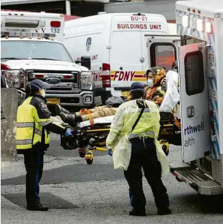  ?? Dave Sanders - 25.mar.20/The New York Times ?? Paciente chega de ambulância ao hospital Elmhurst, em NY