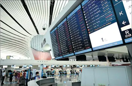  ?? WANG ZHAO / AFP ?? The departures board at Beijing’s Daxing Internatio­nal Airport lists canceled flights (in red) on Monday. Hundreds of flights were canceled in the capital due to torrential downpours and strong winds.