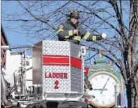  ?? SUBMITTED PHOTO ?? Charlottet­own firefighte­r Bobby Chandler assists in changing the clock near City Hall with a reminder to residents that daylight saving time is a good time to change the batteries in home smoke alarms and test to ensure they are all working properly.