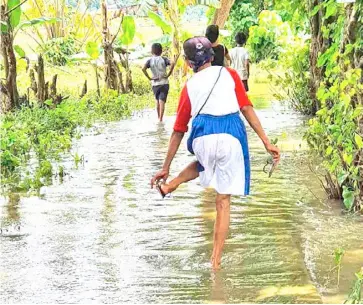  ?? PHOTOGRAPH COURTESY OF LOPEZ LGU ?? FLOODS caused by tropical depression ‘Pepito’ have yet to subside in remote villages in Lopez, Quezon, which received assistance from Senator Bong Go on Friday.