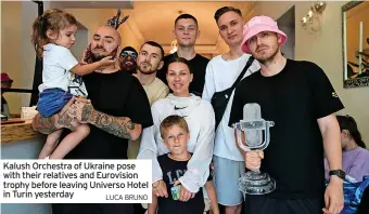  ?? LUCA BRUNO ?? Kalush Orchestra of Ukraine pose with their relatives and Eurovision trophy before leaving Universo Hotel in Turin yesterday