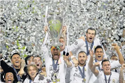  ?? Laurence Griffiths ?? > 2016: Real Madrid lift the Champions League trophy in Milan