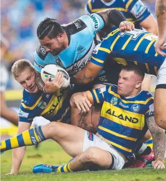  ?? Picture: PHIL HILLYARD ?? Cronulla's Andrew Fifita comes crashing down on Parramatta's Nathan Brown in the NRL clash at ANZ Stadium last night. Cronulla won the match 14-4