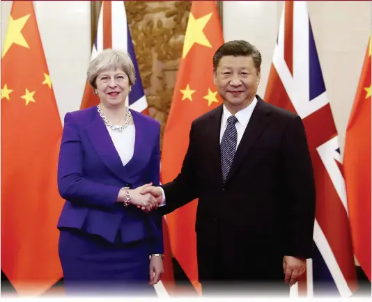  ??  ?? Chinese President Xi Jinping shakes hands with visiting British Prime Minister Theresa May at the Diaoyutai State Guesthouse on Thursday in Beijing.