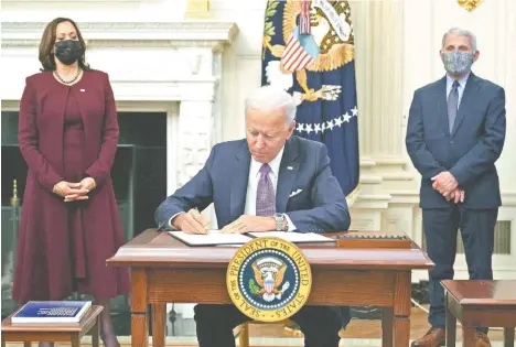  ??  ?? El presidente Joe Biden, ayer al firmar órdenes ejecutivas contra la pandemia del coronaviru­s, en la Casa Blanca en Washington.