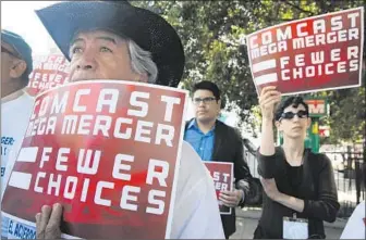  ?? Don Bartletti
Los Angeles Times ?? PROTESTERS RALLY outside the state building in downtown Los Angeles ahead of a California Public Utilities Commission hearing on the proposed Comcast-Time Warner Cable merger.