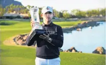  ?? PHOTO: GETTY IMAGES ?? Si Woo Kim, of South Korea, poses with the trophy after putting in to win on the 18th green during the final round of The American Express tournament on the Stadium course at PGA West in La Quinta, California, yesterday.