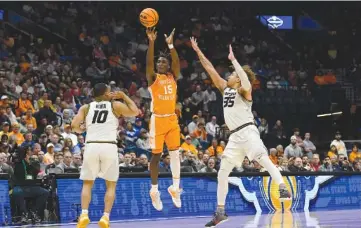  ?? AP PHOTO/JOHN AMIS ?? Tennessee guard Jahmai Mashack (15) shoots a 3-point buzzer-beater Friday between the defense of Missouri guard Nick Honor (10) and forward Noah Carter (35) to end the first half of an NCAA college basketball game in the third round of the Southeaste­rn Conference Tournament in Nashville.