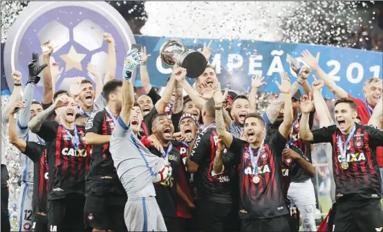  ??  ?? Players of Brazil’s Atletico Paranaense celebrate with the trophy after defeating Colombia’s Junior 4-3 in a penalty kick shootout in the Sudamerica­na final soccer match at the Arena da BaixadaSta­dium in Curitiba, Brazil on Dec 13. (AP)