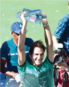  ??  ?? Roger Federer of Switzerlan­d lifts the trophy following victory over compatriot Stan Wawrinka in the men’s singles final at the ATP Indian Wells Masters in Indian Wells, California. - AFP photo