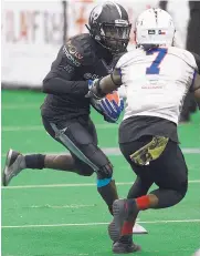  ?? ADOLPHE PIERRE-LOUIS/JOURNAL ?? Duke City receiver Cliff Rhodes, left, tries to evade Texas defender DeWayne Autrey III during Monday night’s CIF playoff game at Tingley Coliseum.