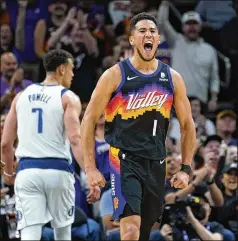  ?? MATT YORK/AP ?? Suns guard Devin Booker celebrates after scoring in a 121-114 win over the Mavericks during Game 1 of their Western Conference playoff series Monday. Booker scored 23 points in his second game back from injury. Luka Doncic led the Mavericks with 45 points, 12 rebounds and eight assists.