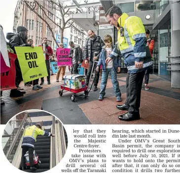  ?? ROSA WOODS/ STUFF ?? A security guard receives the petitions during a climate protest outside the Majestic Centre in Wellington.