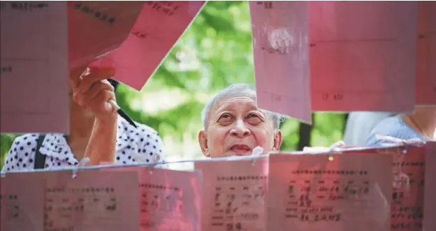  ?? ZHONG ZHENBIN / FOR CHINA DAILY ?? Parents display their children’s resumes at a matchmakin­g corner in Tianhe Park, Guangzhou, Guangdong province.