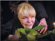  ?? ?? Larysa cries Feb. 11 over the coffin of her husband Volodymyr, a Ukrainian military serviceman who was killed in the east of the country, during his funeral in Kyiv.