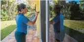  ?? J. OCNER/AP MATIAS ?? Kelly Coulter, 44, paints the trim on the newly installed impact windows at her home in West Palm Beach on Jan. 31.