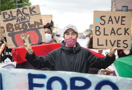  ??  ?? Protesters march down 26th Street in Little Village on Wednesday to denounce the death of George Floyd and urge peace between Latinos and African Americans after days of rising racial tensions.