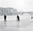  ??  ?? River of ice: a cyclist and walker on the frozen Thames at Windsor in January 1963