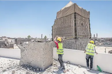  ??  ?? Rebuilding work at a home near the al-Nuri mosque complex, with remains of the heavily damaged al-Hadba minaret in the background.